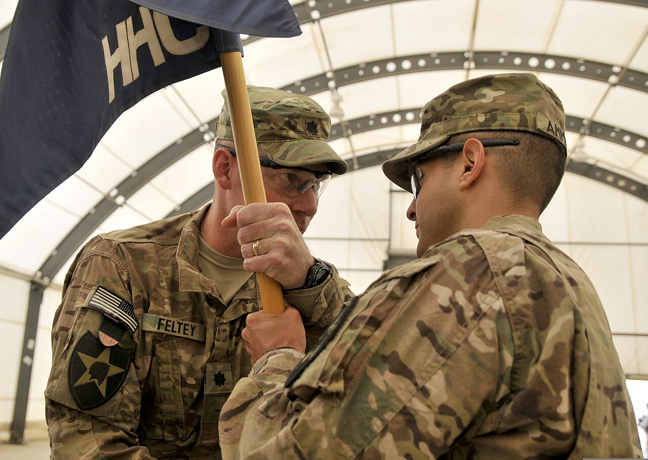 U.S. Army Lt. Col Thomas M. Feltey, left, the commander of the 2nd Battalion, 23rd Infantry Regiment, passes the Headquarters Company guidon to Capt. Barry G. Ammons during a chang